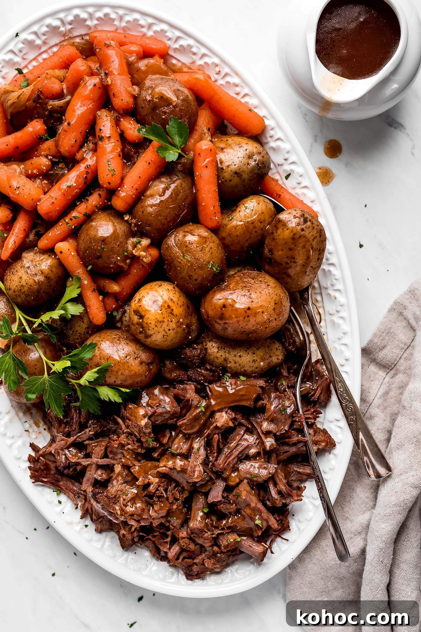 Juicy Instant Pot Pot Roast Recipe for Tender, Quick Dinner 4 A large patter of Pressure Cooker Pot Roast, potatoes, and carrots.