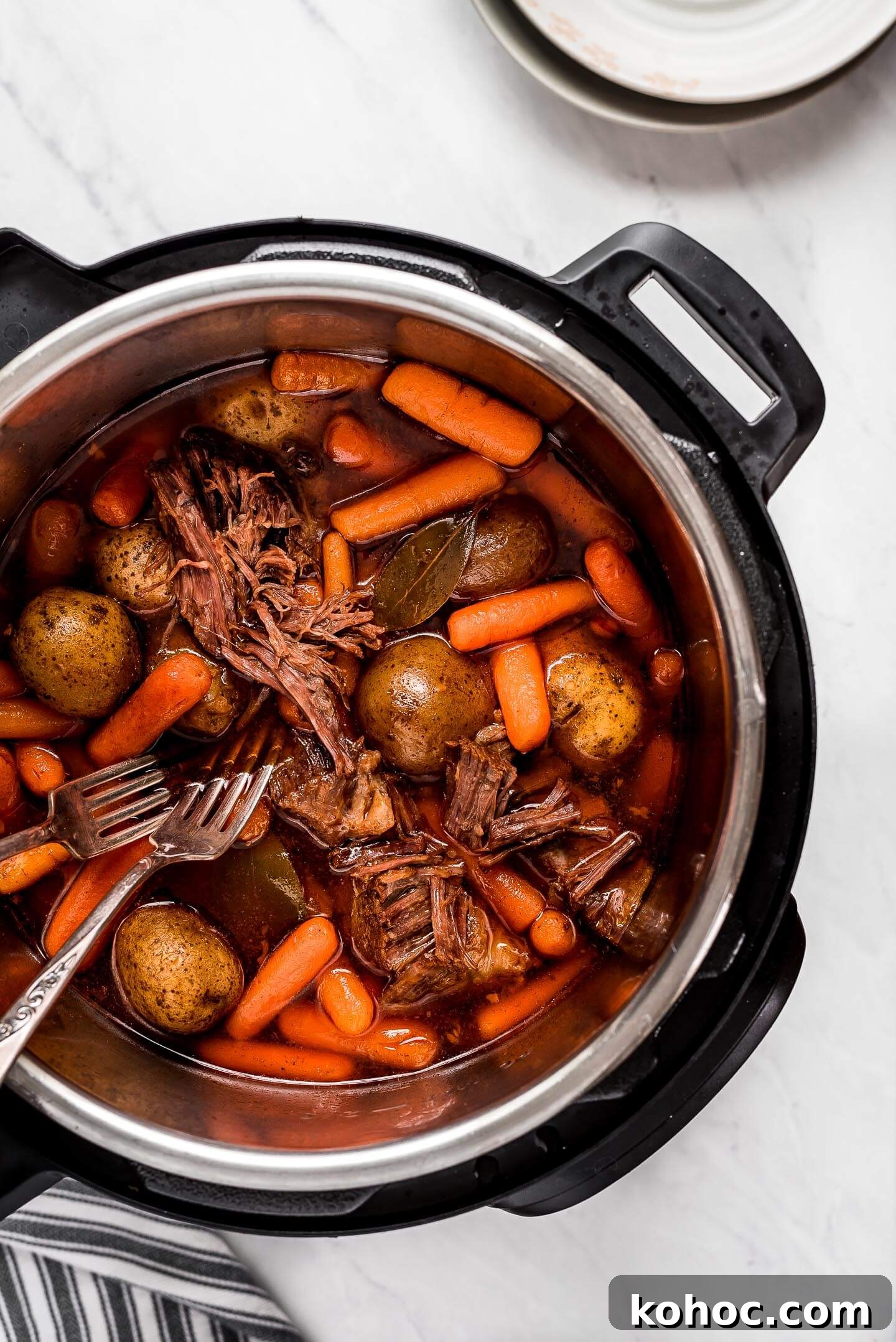 Juicy Instant Pot Pot Roast Recipe for Tender, Quick Dinner 6 Beef, potatoes, carrots, and broth in an Instant Pot.