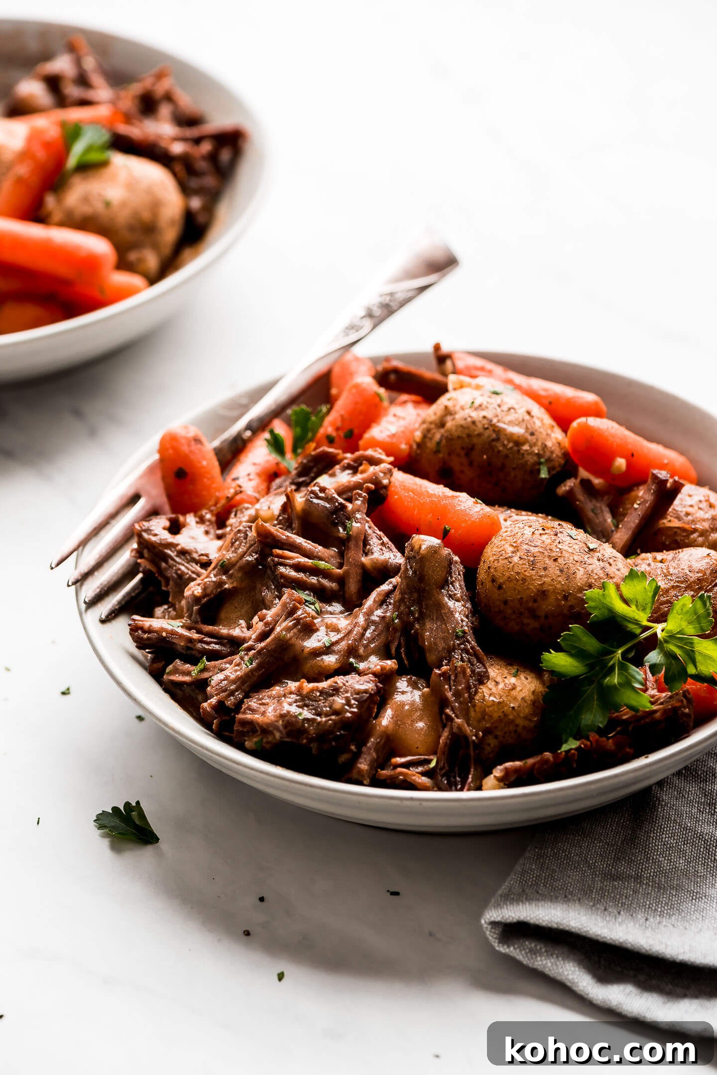 Juicy Instant Pot Pot Roast Recipe for Tender, Quick Dinner 7 Instant Pot Pot Roast in a bowl with baby carrots, baby yukon potatoes, and gravy.