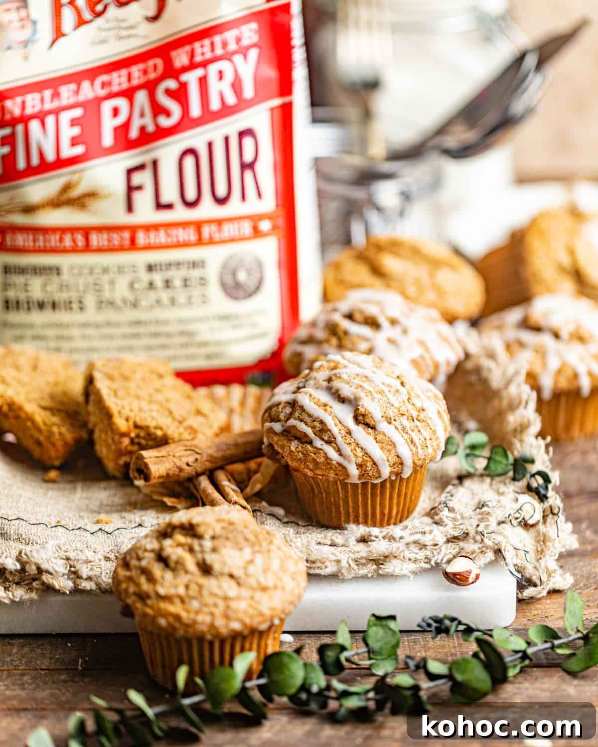 Gingerbread Muffins with Molasses Glaze: Cozy Holiday Treats 3 a gingerbread muffin on a wood table in front of a bag of pastry flour.