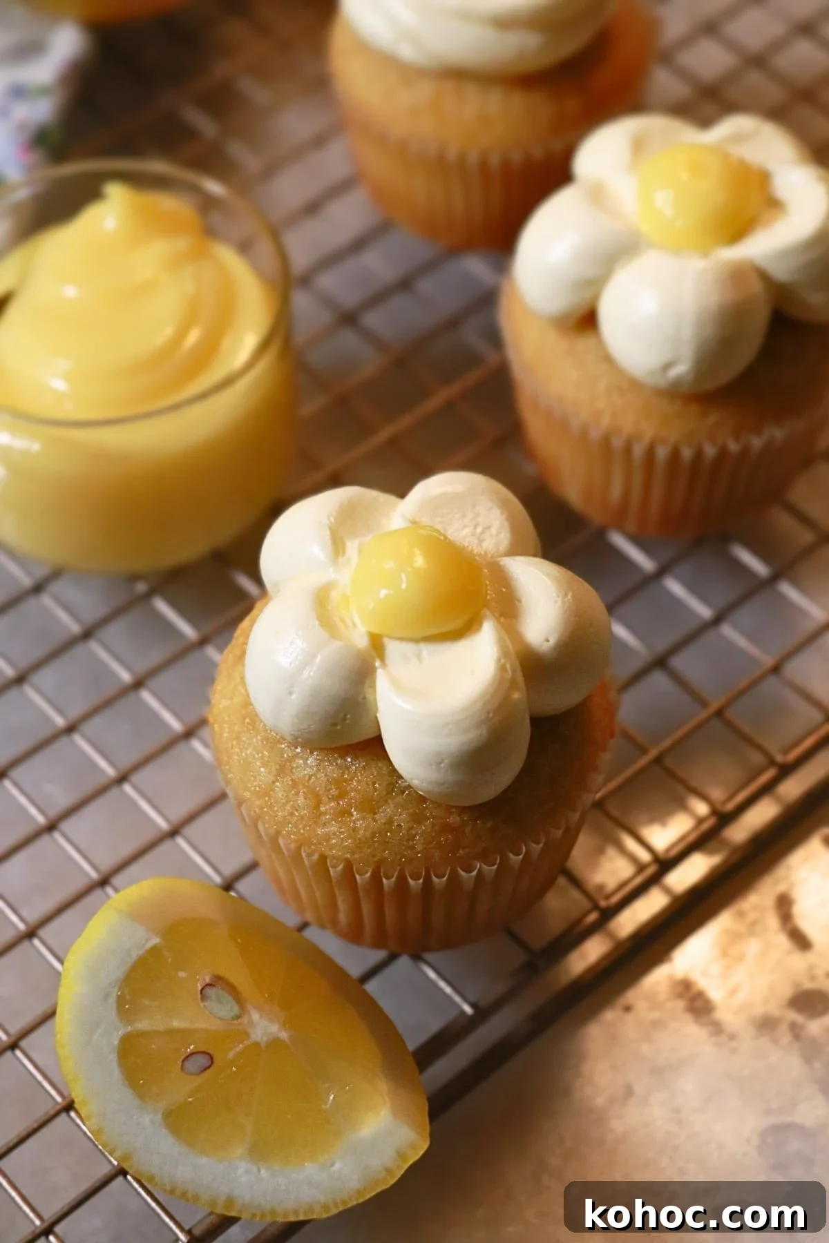 Zesty Lemon Cupcakes Recipe with Creamy Lemon Frosting 2 flower shaped lemon cupcakes that is made with lemon frosting and lemon curd