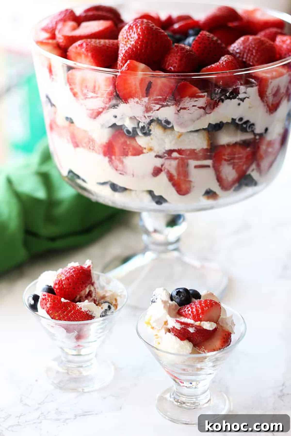 22 Memorial Day Recipes for the Ultimate Backyard BBQ 24 Trifle bowl containing cheesecake filling, angel food cake with strawberries and blueberries.