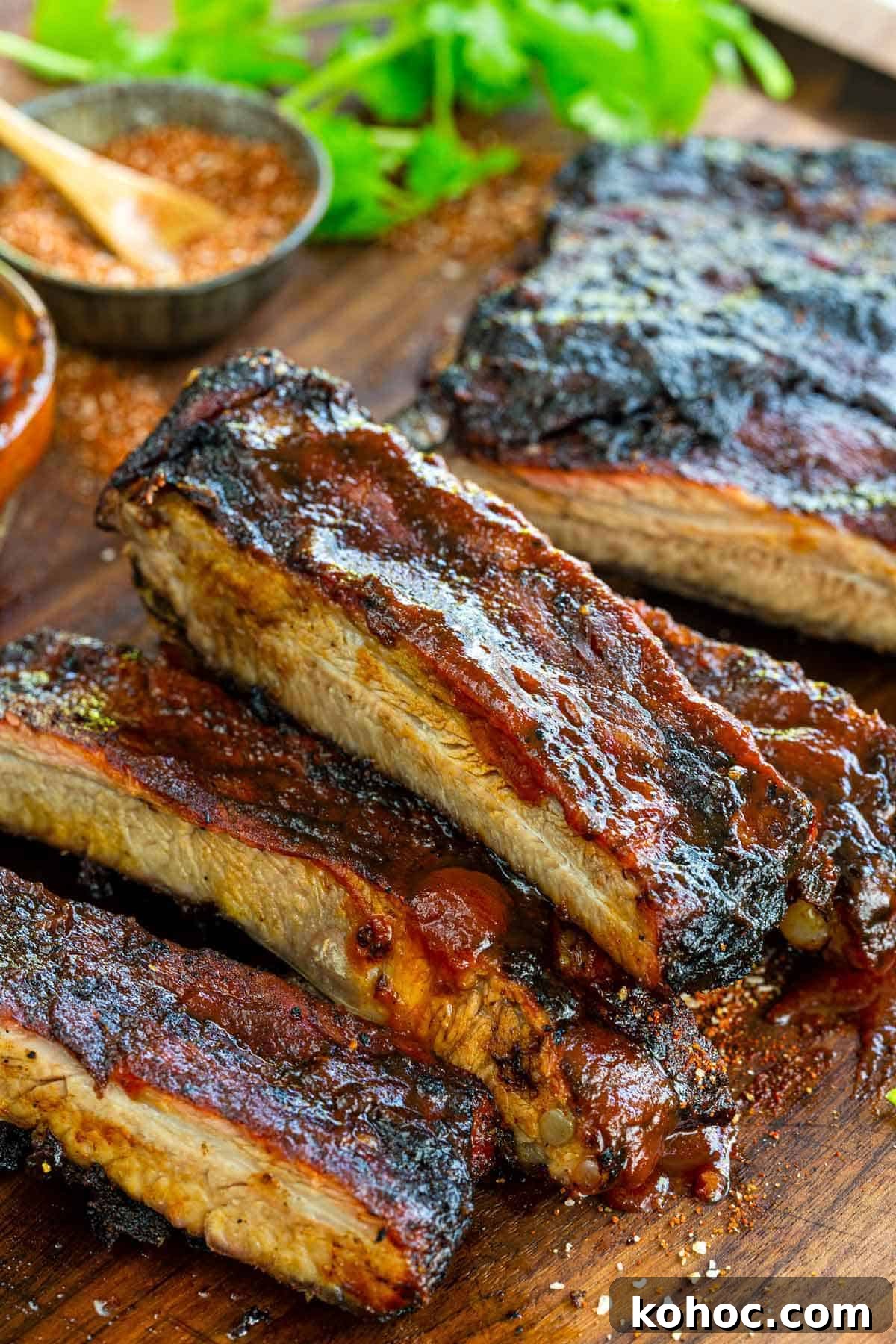 22 Memorial Day Recipes for the Ultimate Backyard BBQ 8 Cut BBQ ribs on a cutting board topped with BBQ sauce.