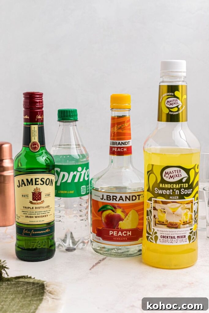 Green Tea Shot Recipe: How to Make the Classic Cocktail 3 Whiskey and other bottles of alcohol needed to make green tea shots on a marble table.