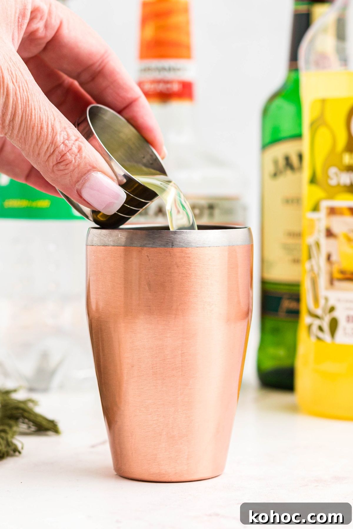 Green Tea Shot Recipe: How to Make the Classic Cocktail 4 Drink mixture being poured into a shot glass.