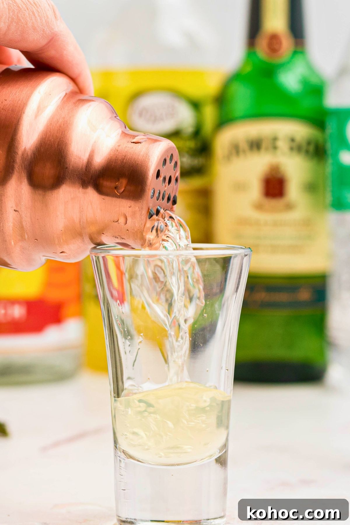 Green Tea Shot Recipe: How to Make the Classic Cocktail 5 Drink mixture being poured into a shot glass.