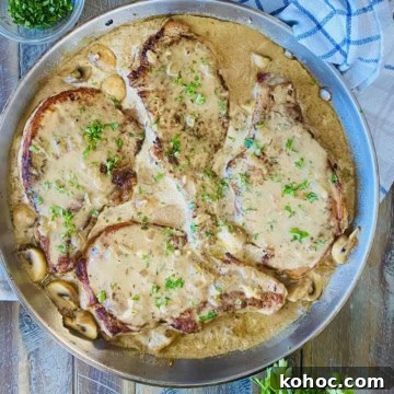 4 pork chops in a sauté pan with gravy.