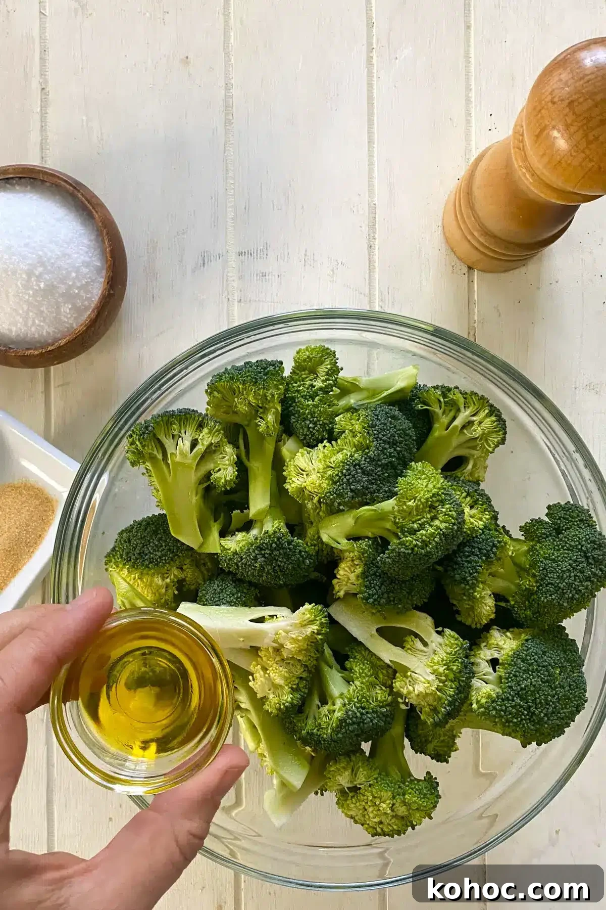 Crispy Garlic Broiled Broccoli Recipe — Quick Crispy Broccoli 5 raw broccoli florets in a glass bowl and adding olive oil.