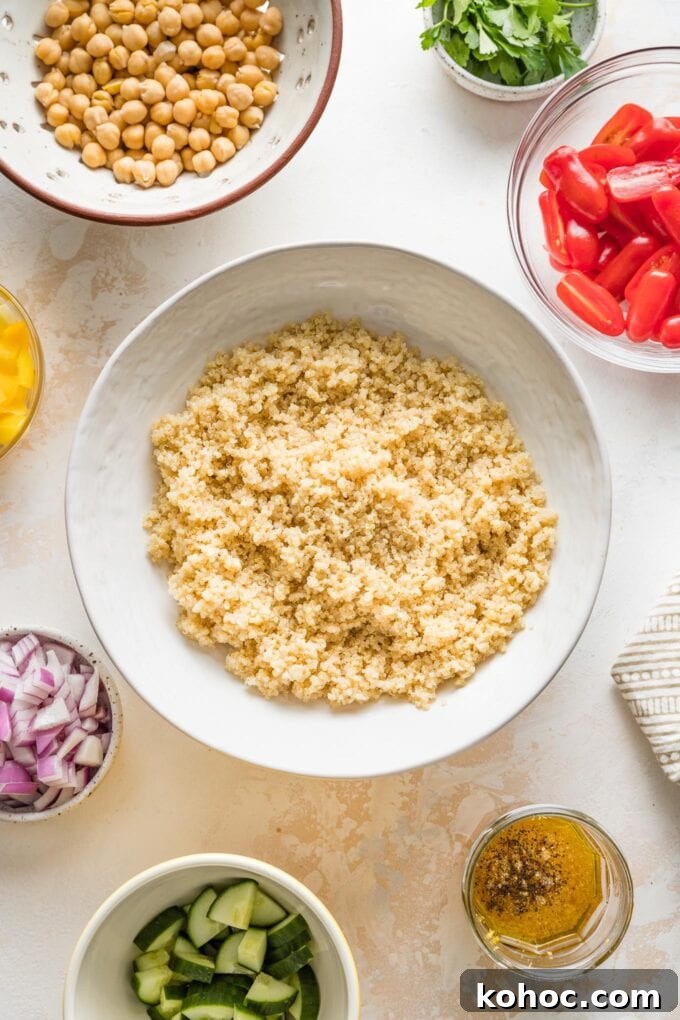 Protein-Packed Quinoa and Chickpea Salad for Meal Prep 4 Serving bowl full of cooked quinoa, cooling to room temperature.