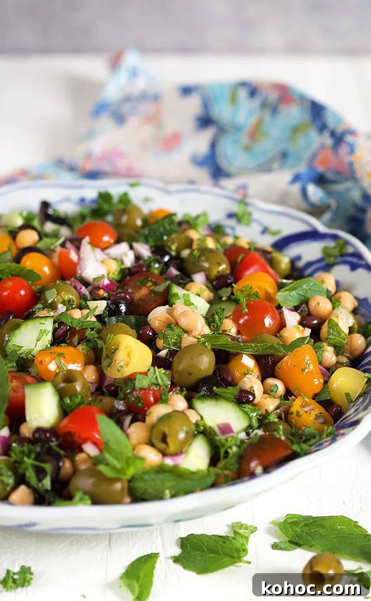 Mediterranean Chickpea Salad with Lemon, Herbs & Feta 5 Close up of Mediterranean Chickpea Salad in a blue and white bowl.
