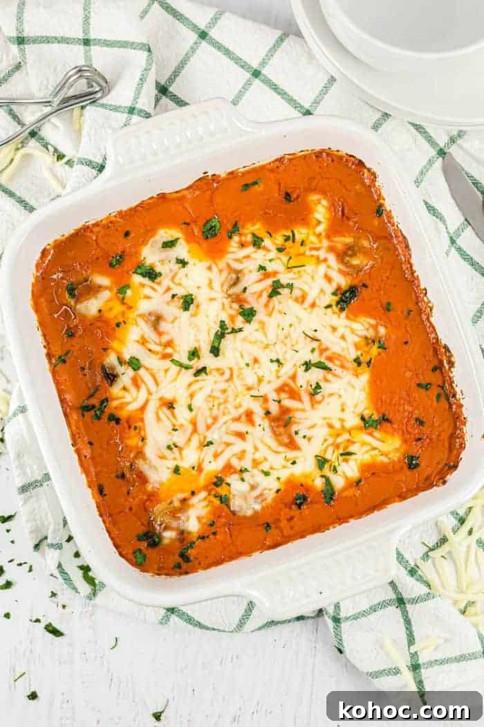 overhead view of keto meatball casserole in a white casserole dish next to dish towel