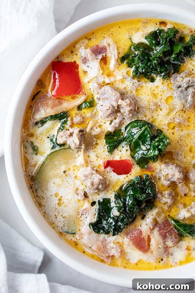 overhead view of zuppa toscana soup in a large ceramic pot with a soup ladel