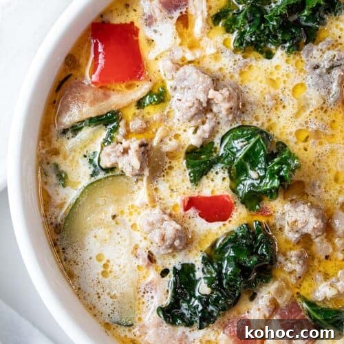 overhead view of zuppa toscana soup in a large ceramic pot with a soup ladel