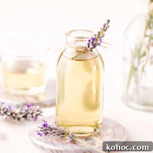 Lavender and Rose Ice Cream Recipe: Floral Homemade Gelato 2 Lavender syrup in a clear glass jar, with a sprig of fresh lavender tied to the top.
