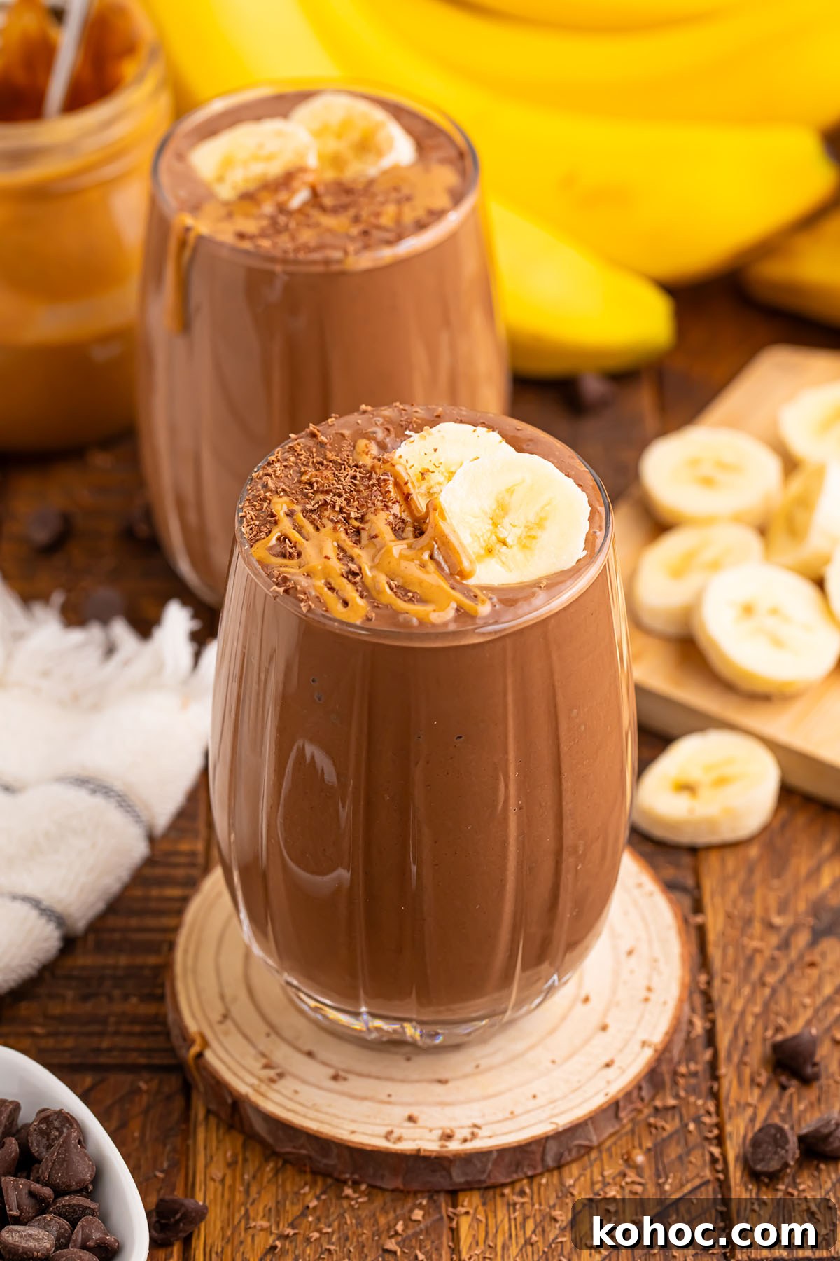 Creamy Chocolate Peanut Butter Banana Smoothie 2 Chocolate Peanut Butter Banana Smoothie is served in a glass and topped with sliced bananas.