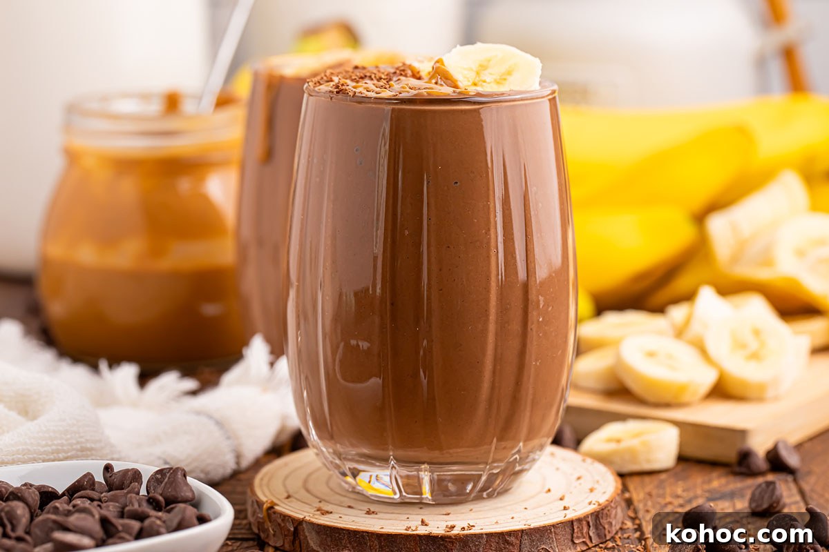 Creamy Chocolate Peanut Butter Banana Smoothie 7 Chocolate Peanut Butter Banana Smoothie is served in a glass and topped with sliced bananas.