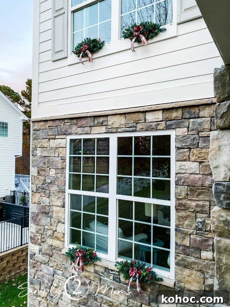 Create Fluffy Christmas Bows in 5 Simple Steps 11 exterior view of home with swags hung on double windows on first floor and second floor