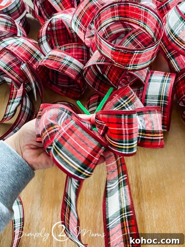 Create Fluffy Christmas Bows in 5 Simple Steps 9 hand holding ribbon in process of making diy bow