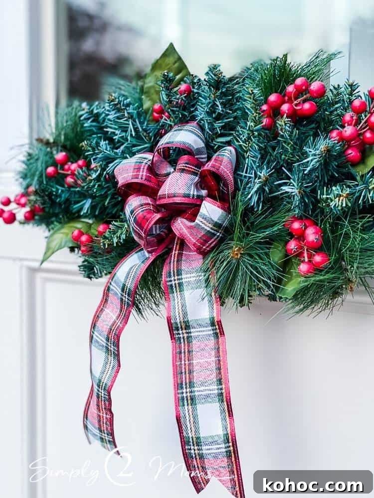 Create Fluffy Christmas Bows in 5 Simple Steps 10 window swag with greenery and berries adorned with plaid fluffy bow hung on outside of window