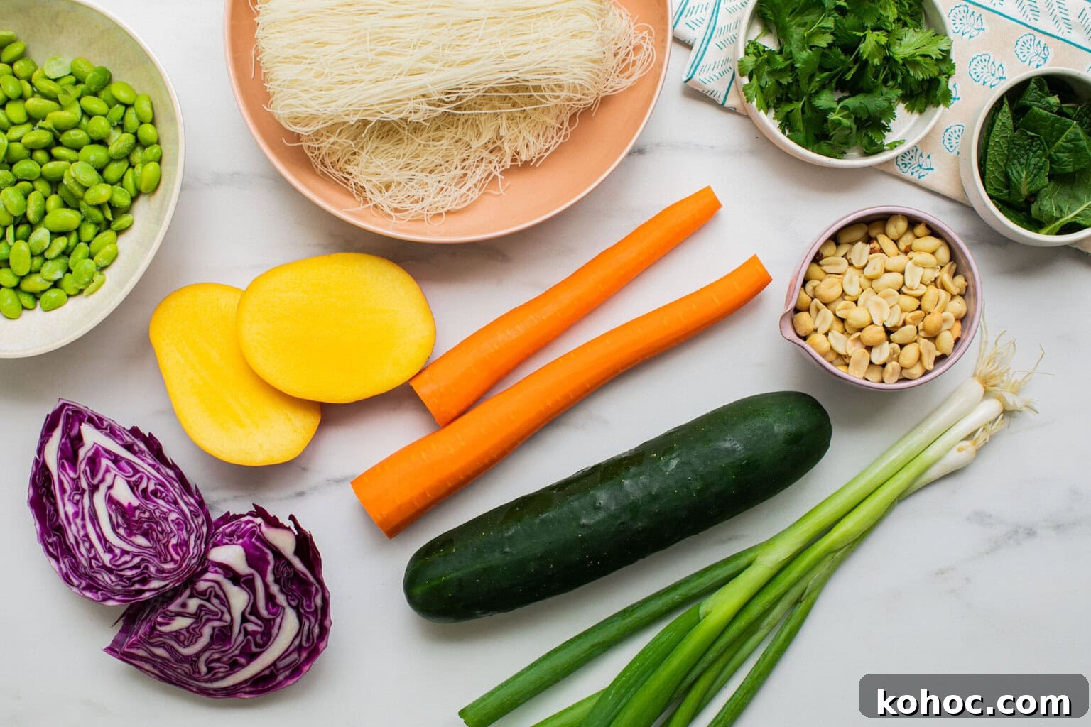 thin rice noodles, herbs, peanuts, carrots, cucumber, green onions, cabbage, mango, edamame