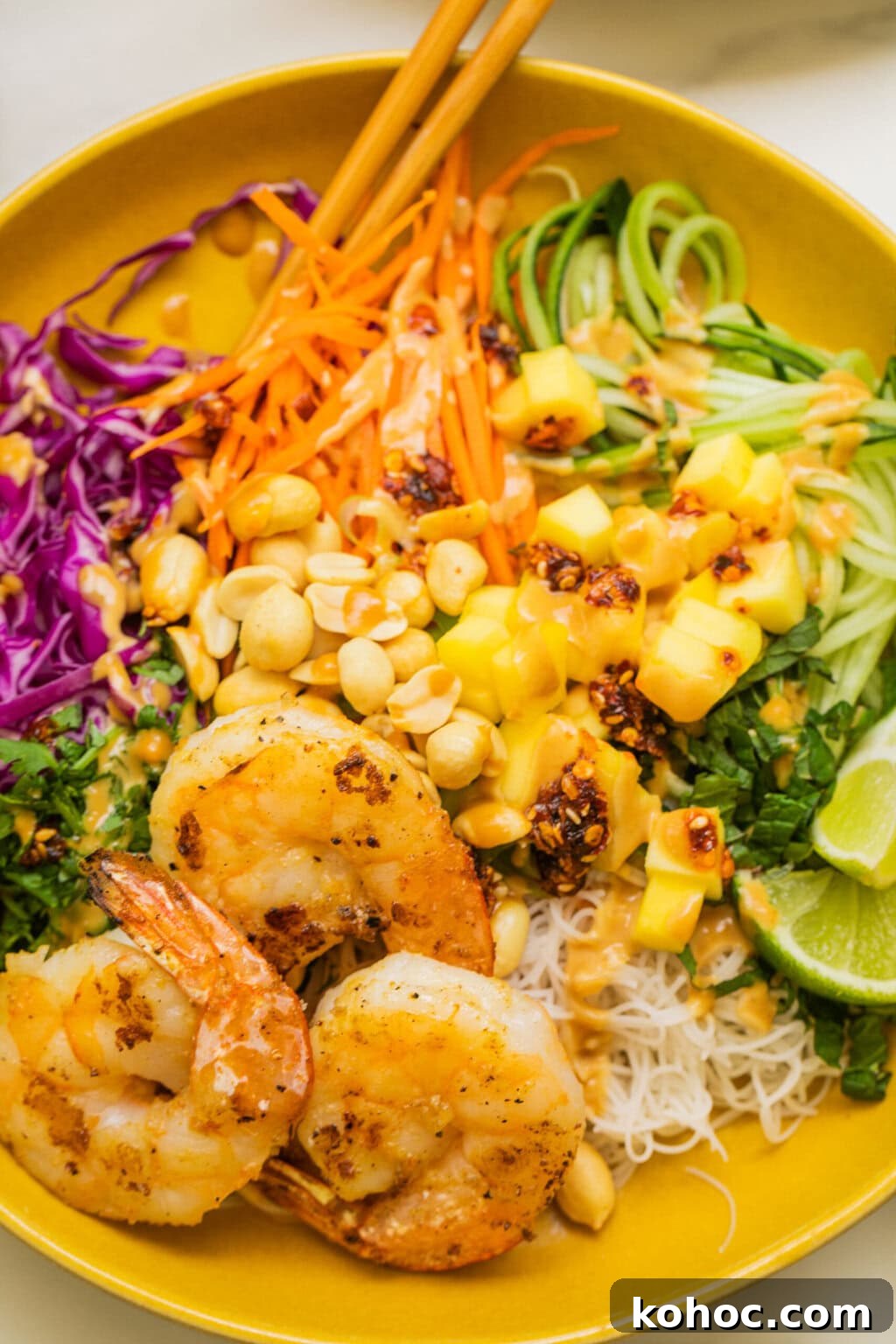 close up shot of the spring roll bowl with peanut sauce on top and shrimp