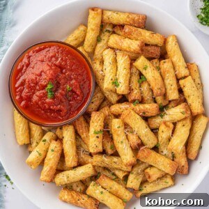 Crispy Air Fryer Pasta Chips Recipe—Quick Snack Idea 9 A plate of air fried pasta with a small bowl of marinara sauce.