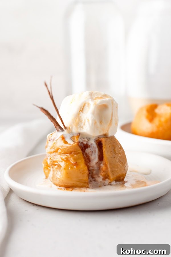 Cinnamon Baked Apples on a plate covered with ice cream. 