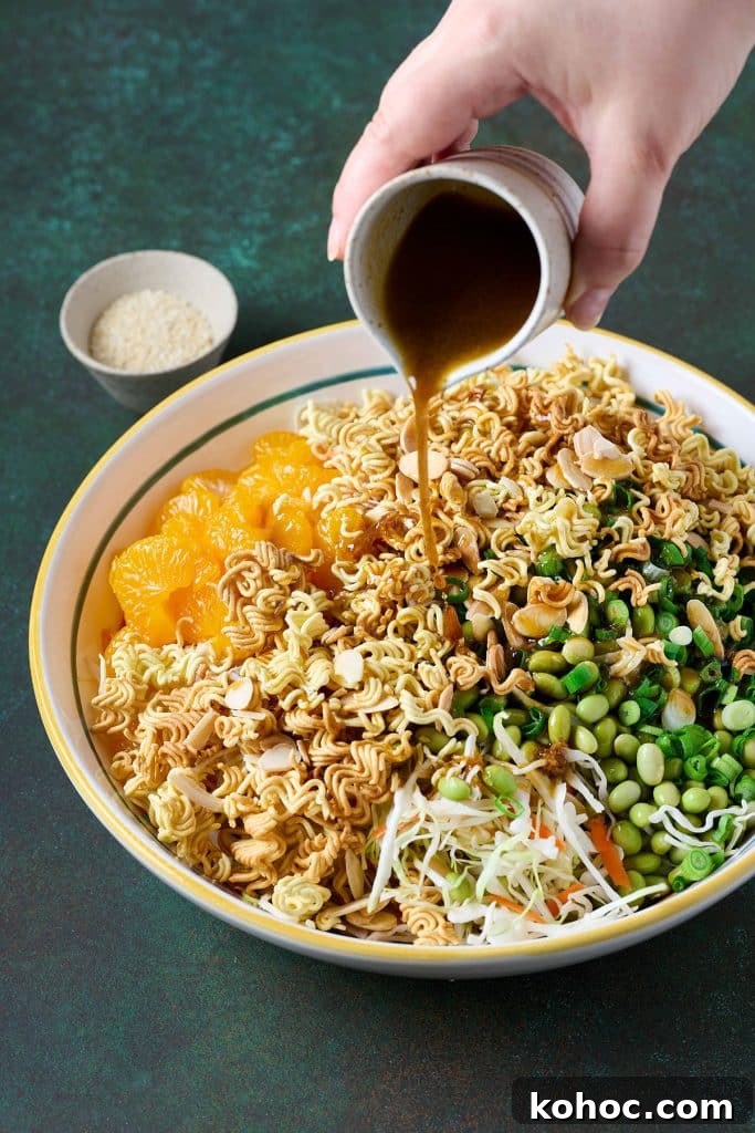 Crunchy Ramen Noodle Salad with Cabbage & Almonds 11 Salad dressing pouring over salad
