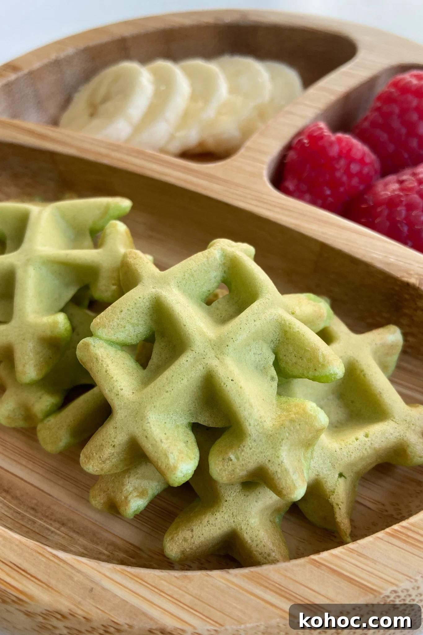 Green Spinach Banana Waffles Recipe | Fluffy & Nutritious Breakfast 2 Spinach banana waffles served with sliced bananas and raspberries