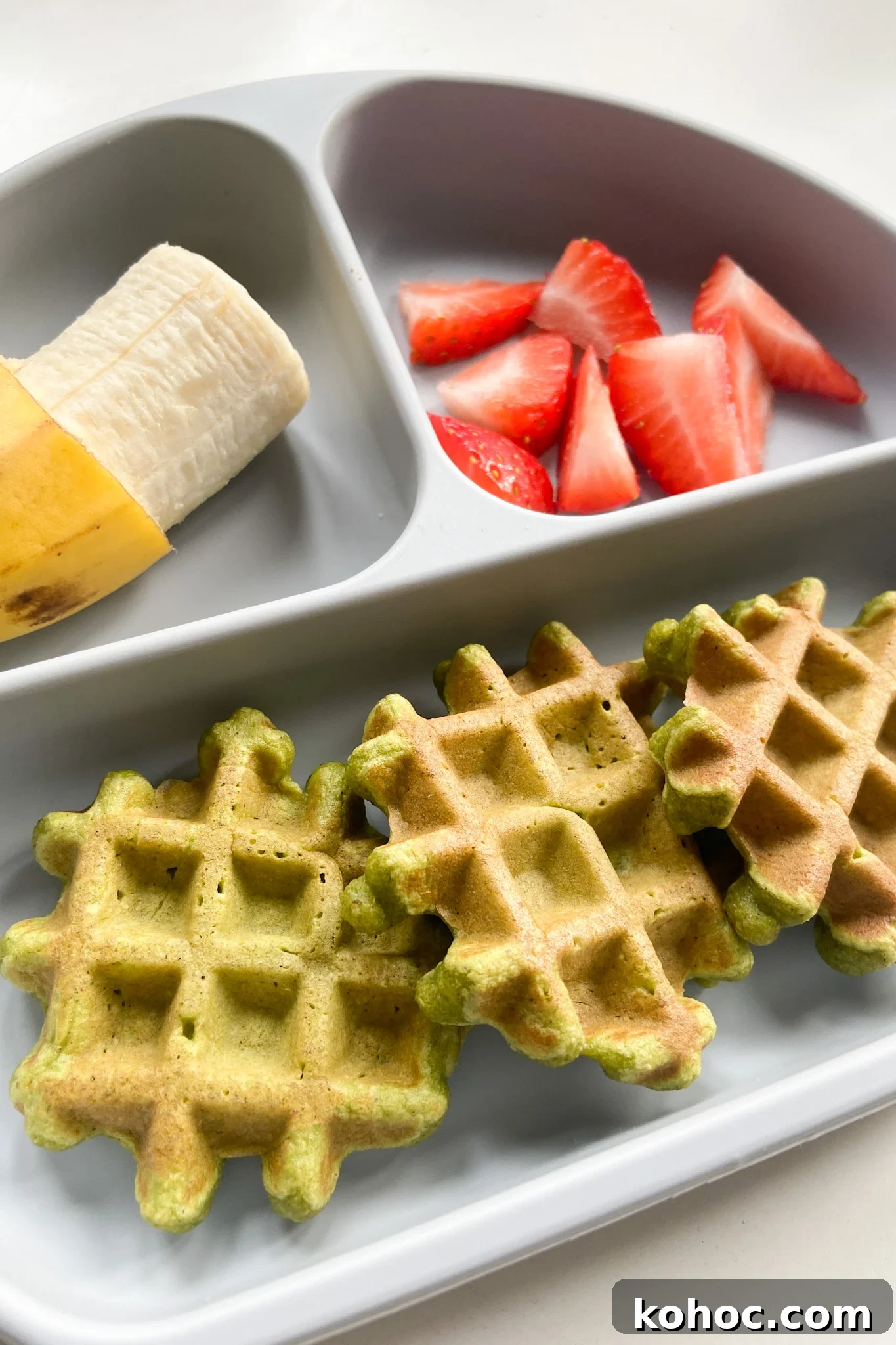 Green Spinach Banana Waffles Recipe | Fluffy & Nutritious Breakfast 6 Spinach banana waffles served with a banana and strawberries