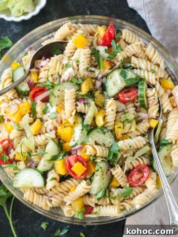 Pepperoncini Pasta Salad in a large bowl with fresh parsley scattered around the bowl.
