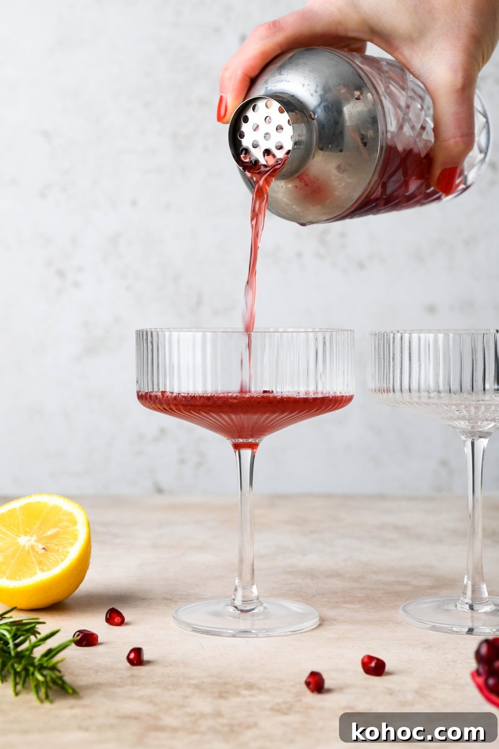 Pomegranate Champagne Cocktail with Gin or Vodka for Holidays 11 How to make Festive Pomegranate Champagne Cocktail: Straining the pomegranate base into champagne coupes