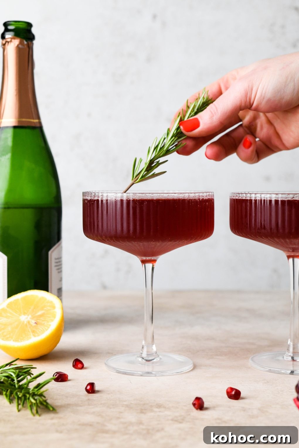 Pomegranate Champagne Cocktail with Gin or Vodka for Holidays 13 How to make Festive Pomegranate Champagne Cocktail: Topping the cocktail with a sprig of rosemary
