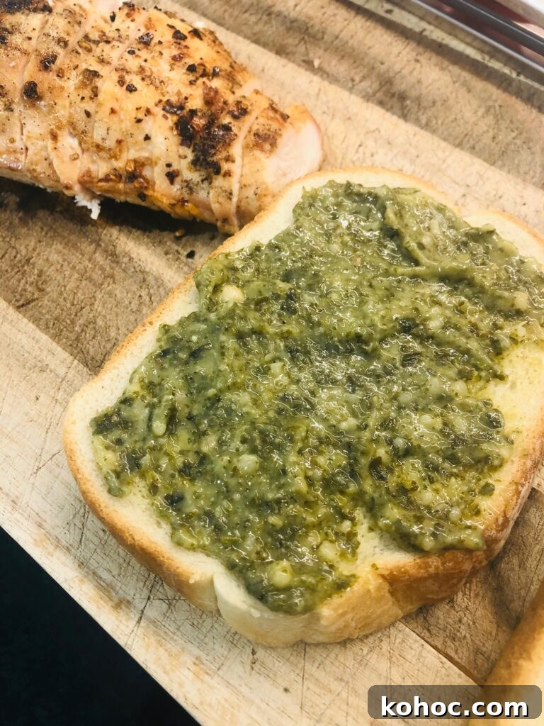 Caprese Chicken Panini Recipe: Melty Tomato, Basil & Mozzarella 2 piece of bread with pesto spread on it for chicken caprese paninis