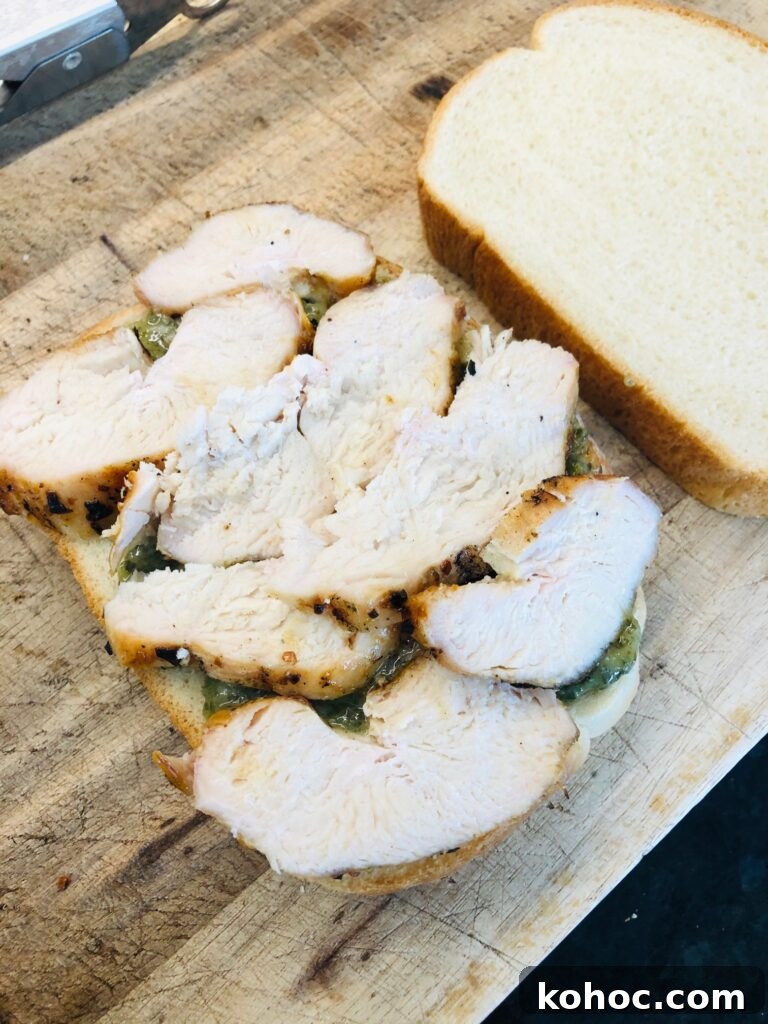 Caprese Chicken Panini Recipe: Melty Tomato, Basil & Mozzarella 3 adding sliced chicken to the panini