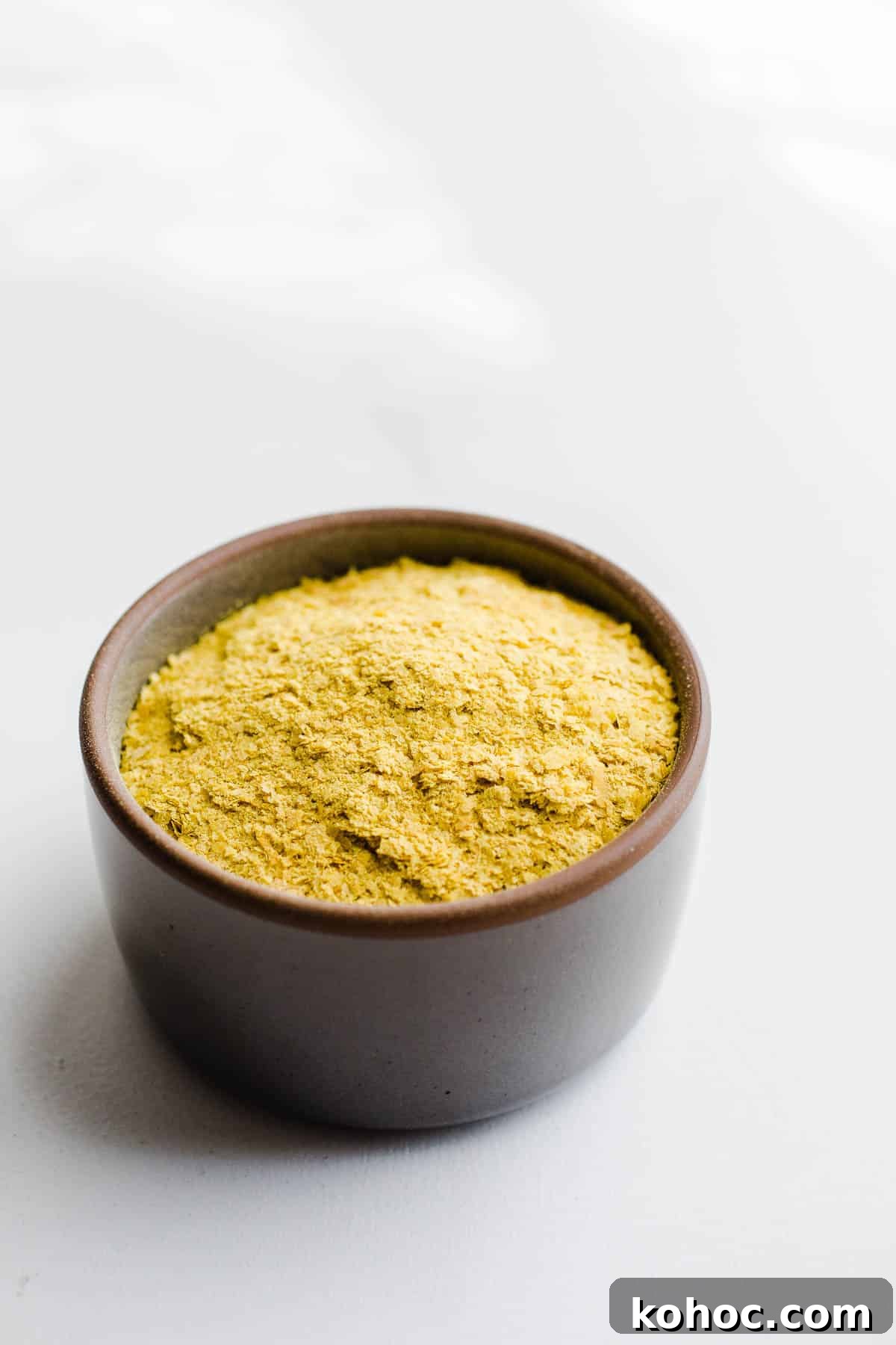 Is Nutritional Yeast Safe for a Gluten-Free Diet? 4 Yellow seasoning in a small gray bowl.