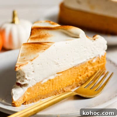 A slice of pumpkin pie on a plate with a fork.