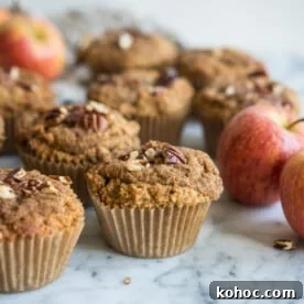 paleo apple cinnaomon muffins on a marble board surrounded by apples