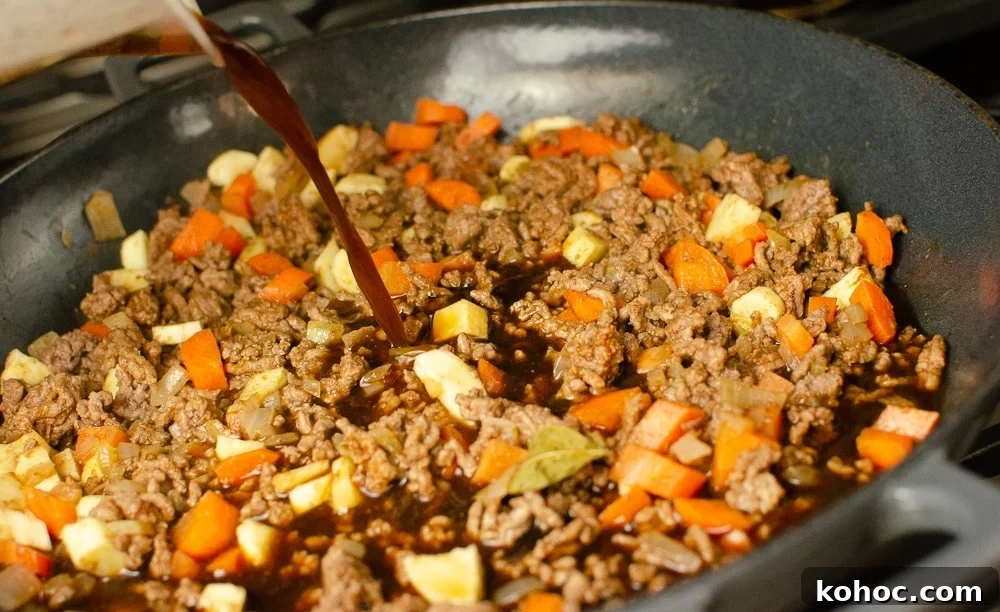 Curried Beef Mince Hotpot Recipe for Comforting Family Dinners 15 Beef stock being added to the dish to make mince hotpo