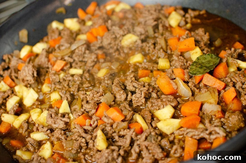 Curried Beef Mince Hotpot Recipe for Comforting Family Dinners 16 Mince carrots, parsnips and curry leaves all cooking in a cast iron dish