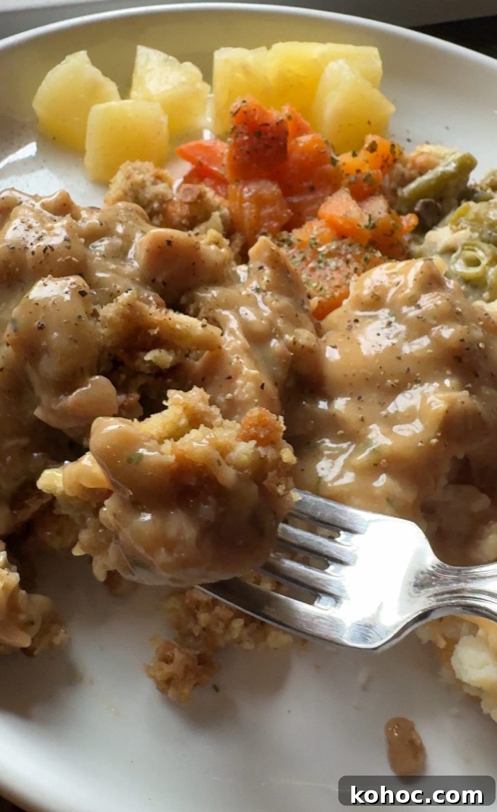 Thanksgiving Dinner Ideas Using Dollar Tree Finds 7 A fork with a chunk of stuffing covered in gravy.