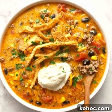 Creamy Chicken Taco Soup Recipe for Cozy Weeknight Meals 9 bowl of taco soup with sour cream, cilantro, and cheese added on top.
