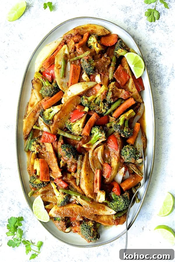 Photo of Curried Roast Vegetables on platter garnished with lime wedges and cilantro.