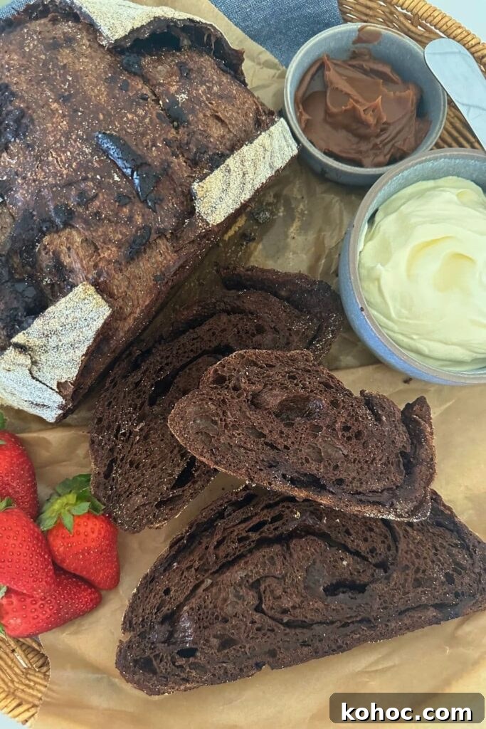 15+ Decadent Chocolate Sourdough Recipes to Try 12 A loaf of sourdough chocolate bread that has been sliced and laid out so you can see the rich interior. There is also some whipped cream and berries in the display.