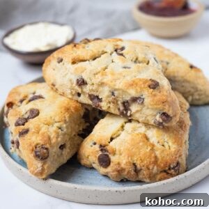 15+ Decadent Chocolate Sourdough Recipes to Try 15 Close up of golden sourdough chocolate chip scones stacked on a plate.