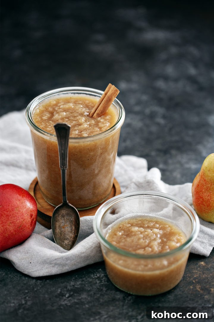 Homemade Pear Sauce Recipe: Smooth, Sweet, and Simple 2 jars of homemade pear sauce with a spoon on a dark background