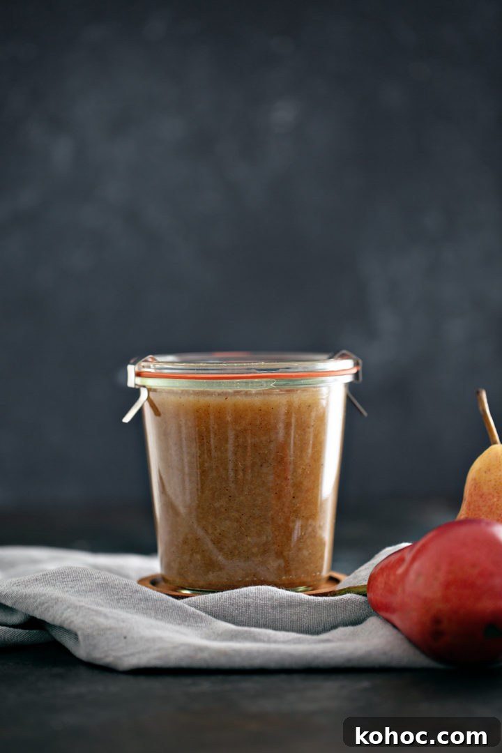Homemade Pear Sauce Recipe: Smooth, Sweet, and Simple 6 jar of canned pear sauce next to fresh pears on a dark background