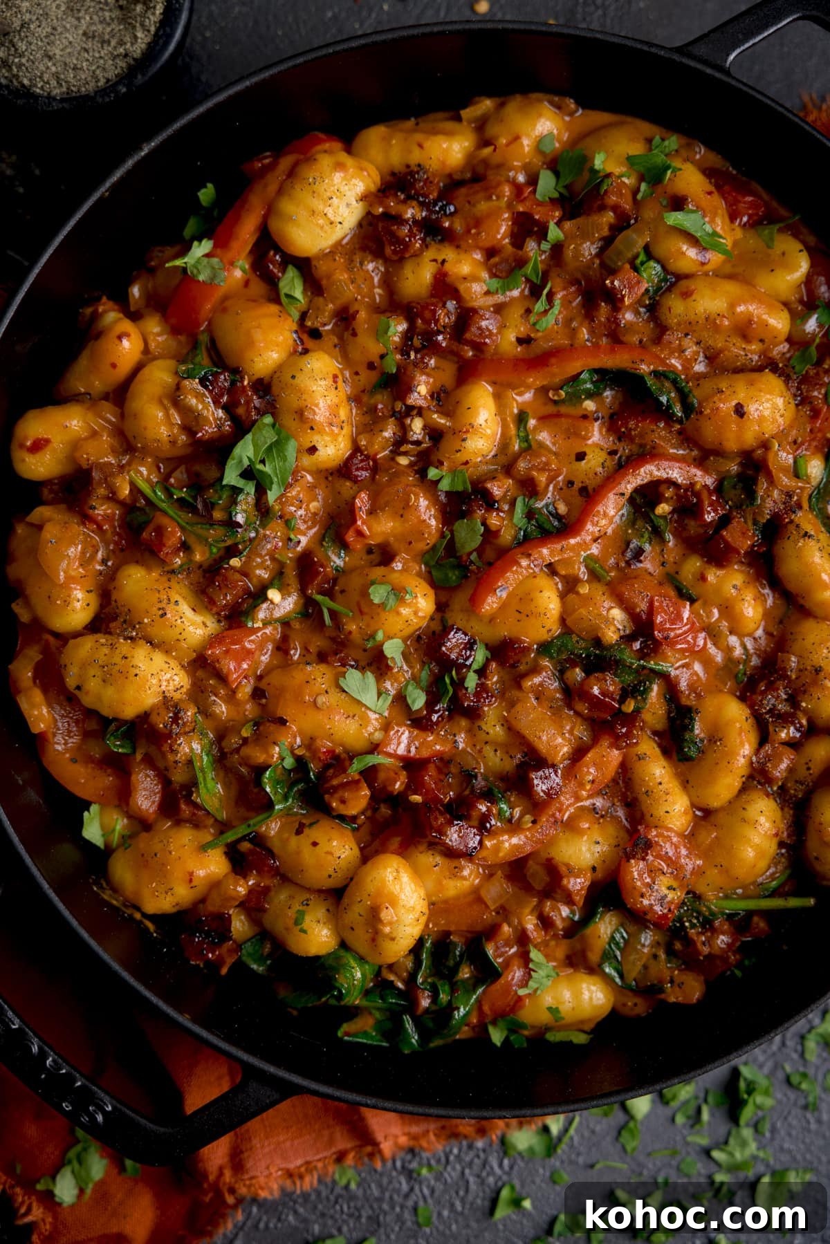 Close up overhead of a pan filled with gnocchi and chorizo in harissa sauce.