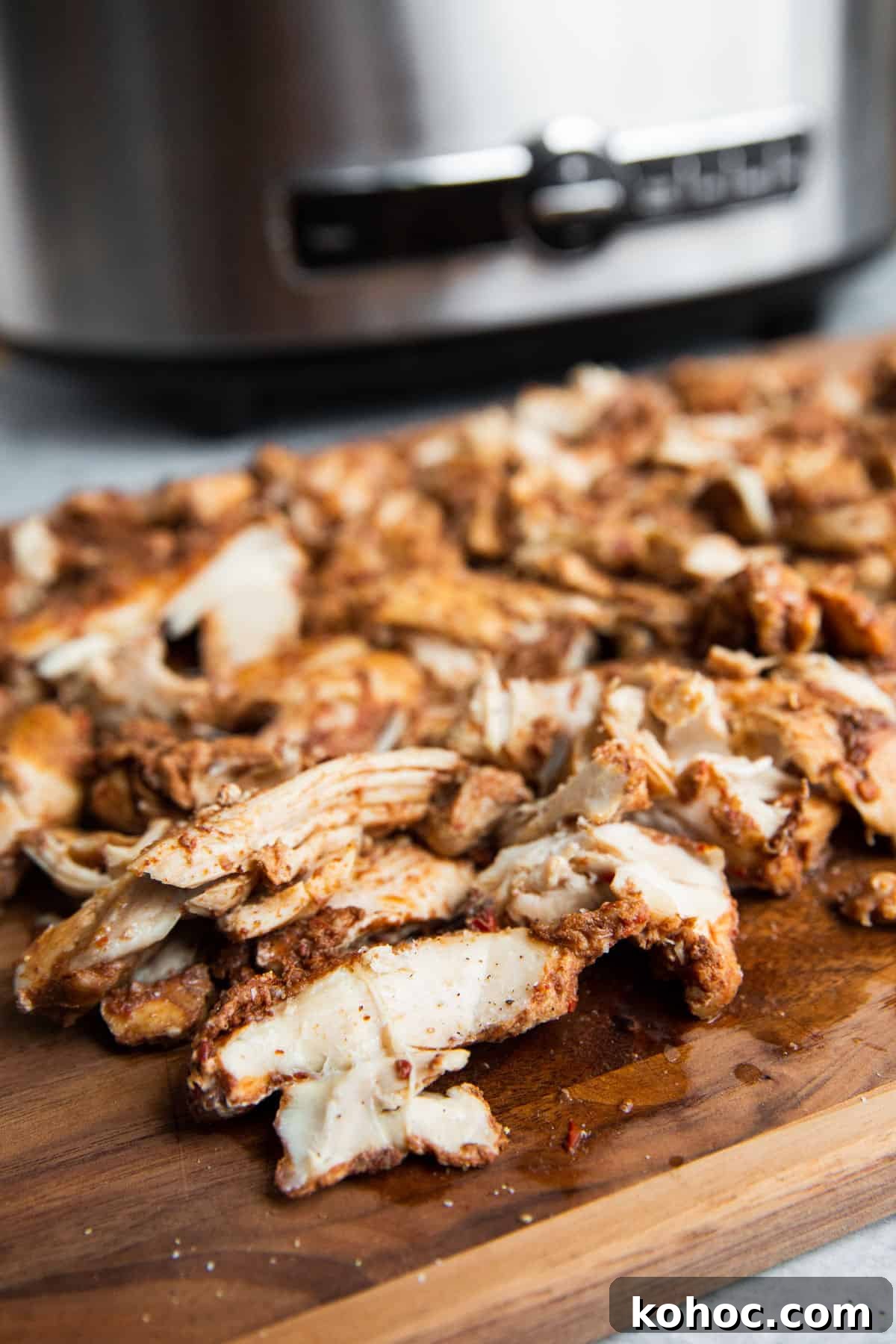 Slow-Cooker Shredded Chipotle Chicken Recipe for Tacos & Bowls 3 a close up photo of shredded chipotle chicken on a cutting board