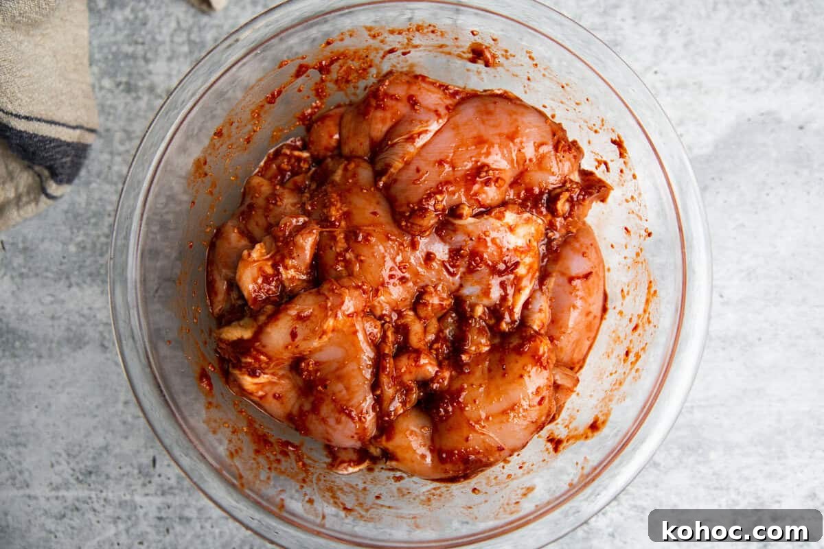 Slow-Cooker Shredded Chipotle Chicken Recipe for Tacos & Bowls 5 chicken in a marinade in a bowl